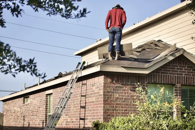 Professional roofer working on a residential roof in Marilla
